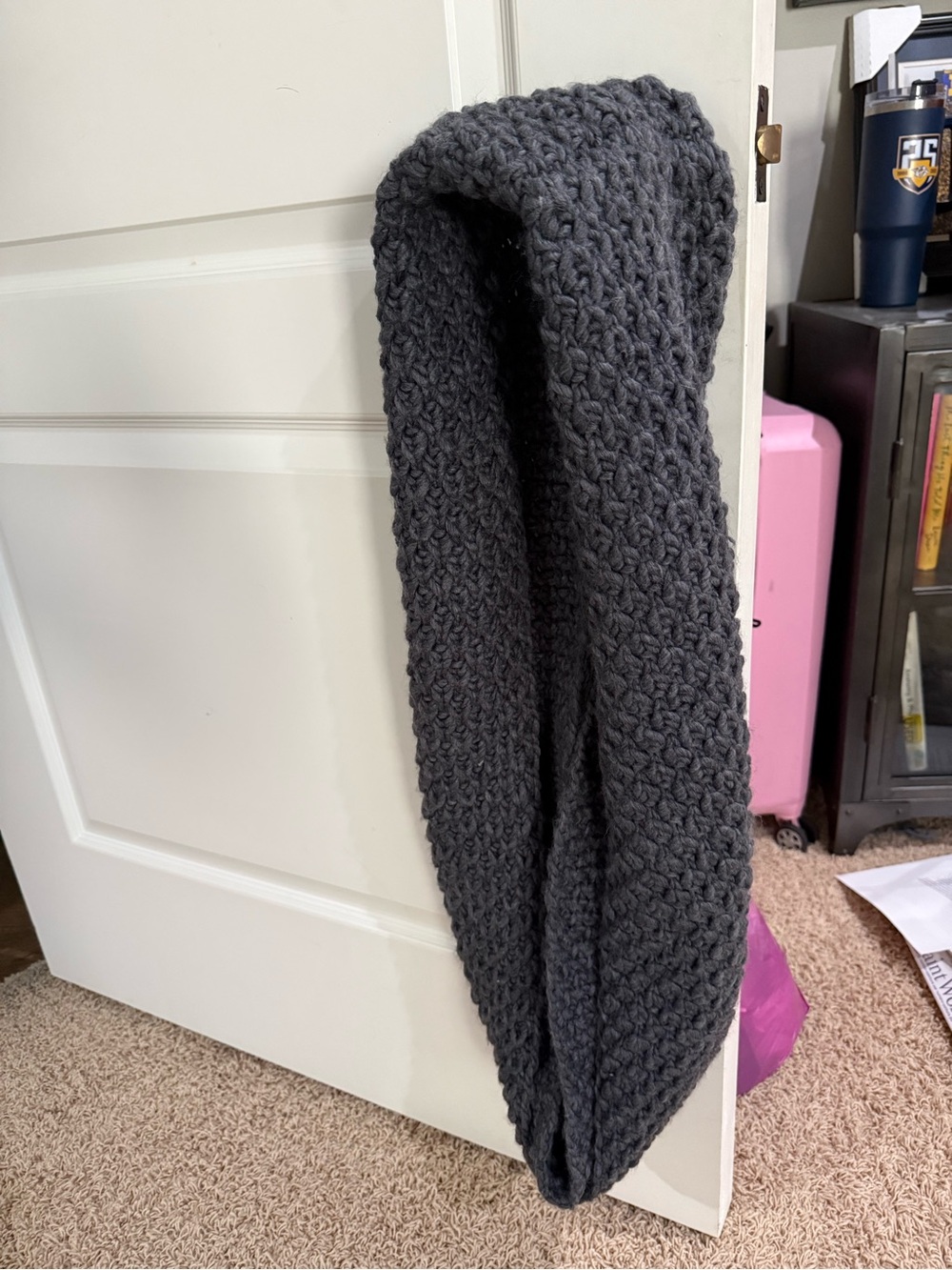 Gray knitted loop hanging on door